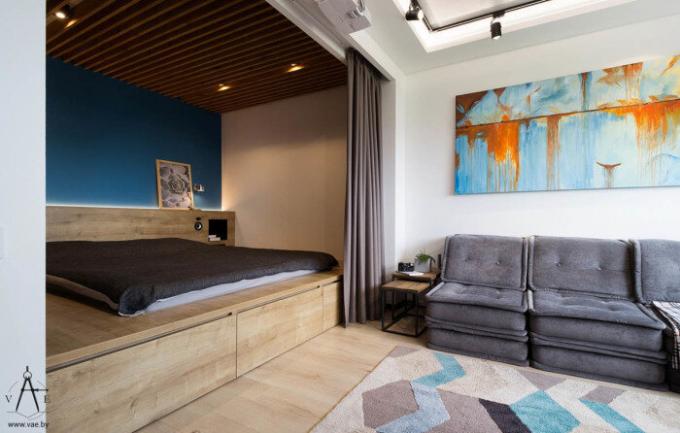Lesena niša z zaveso ločuje spalni prostor z dnevno sobo v stanovanju 48 kvadratnih metrov.