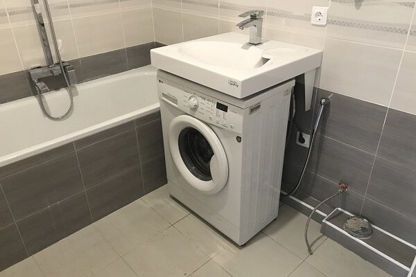 Pralni stroj pod umivalnikom v kopalnici