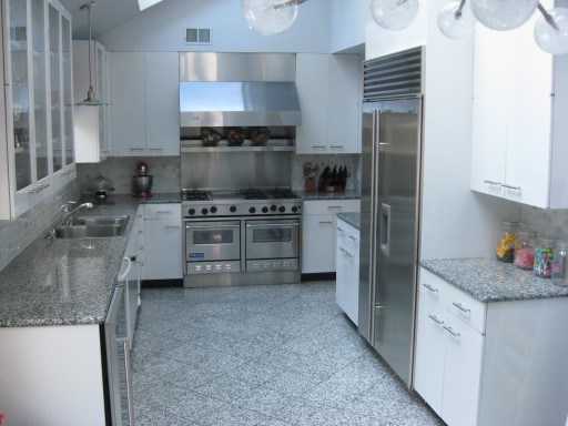 Fotografija prikazuje klasično oblikovalsko možnost: siva kuhinja in belo pohištvo.