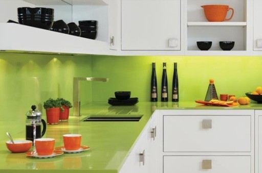 Pult in predpasnik svetlega apnenčastega odtenka izgledata odlično v kombinaciji z belimi kuhinjskimi frontami in oranžnimi jedmi.