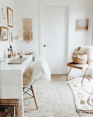 Domača pisarna v svetlih odtenkih, bela polirana miza, makrame, majhna preproga, pleteni predmeti
