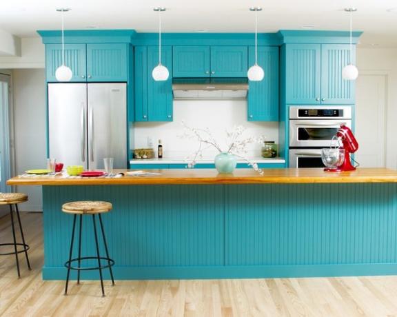 Kuhinjski set v turkizni barvi v kombinaciji s svetlimi stenami in tlemi