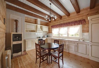 Kuhinja v stilu Provence z lesenimi tlemi in stropnimi tramovi.