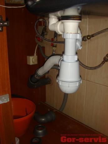 Pravilna organizacija odtočnega kota od sifona do kanalizacijske cevi, izdelana z valovito cevjo